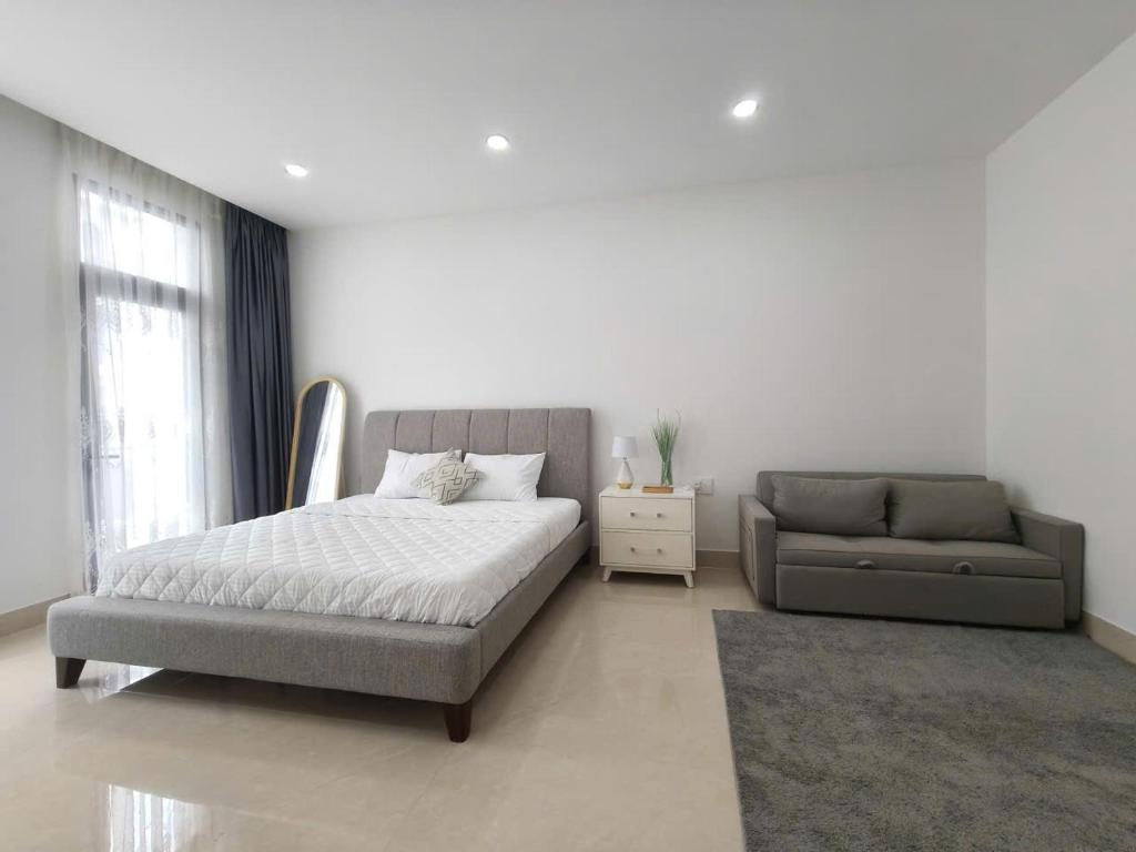 Gò CôngLà Lá 2 Vinhome Grand Park的带床和沙发的卧室