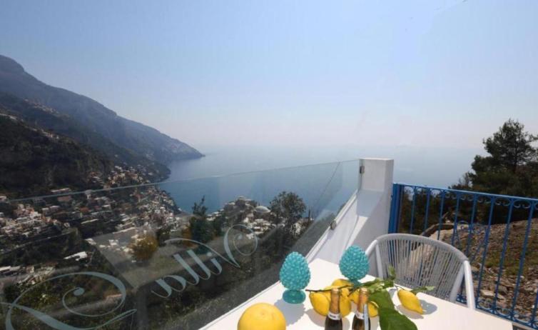 a table with fruit on it with a view of the ocean at Villa Dei SRLS in Positano - Camere in Positano