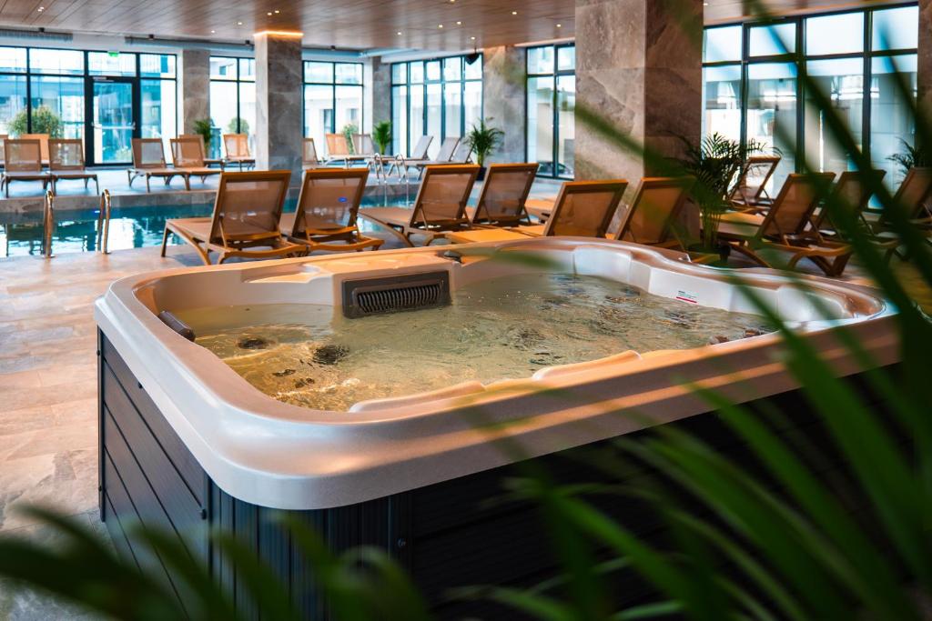 a large hot tub in a hotel lobby with chairs at SIA in Odyssey Pool & Spa Resort in Năvodari