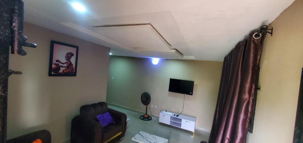 a living room with a couch and a tv at 2 bedroom service apartment in Ibadan