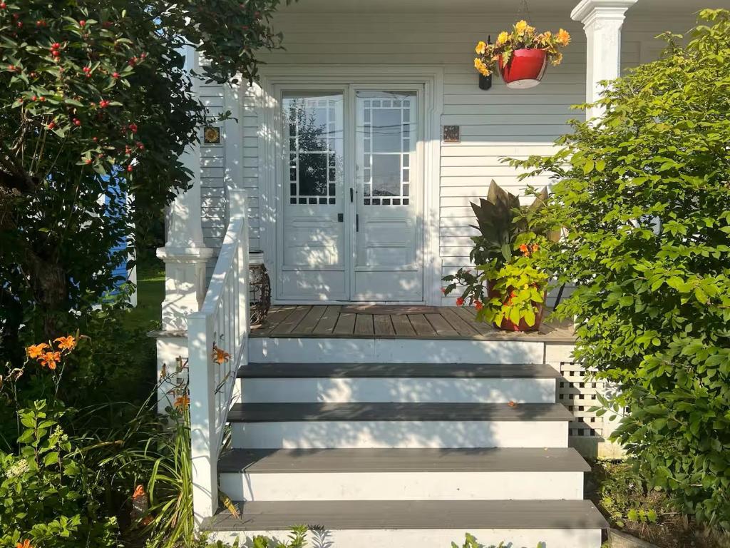a front door of a white house with stairs at Falls Farmstead 1865 Ellis House - Apt 3 in Ellsworth
