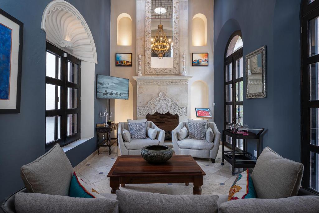 un soggiorno con pareti blu e camino di Casa Elegante, 3BR Modern Retreat in Centro San Miguel de Allende a San Miguel de Allende