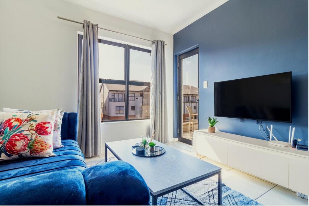 a living room with a blue couch and a tv at Nom’s Amsterdam in Northriding