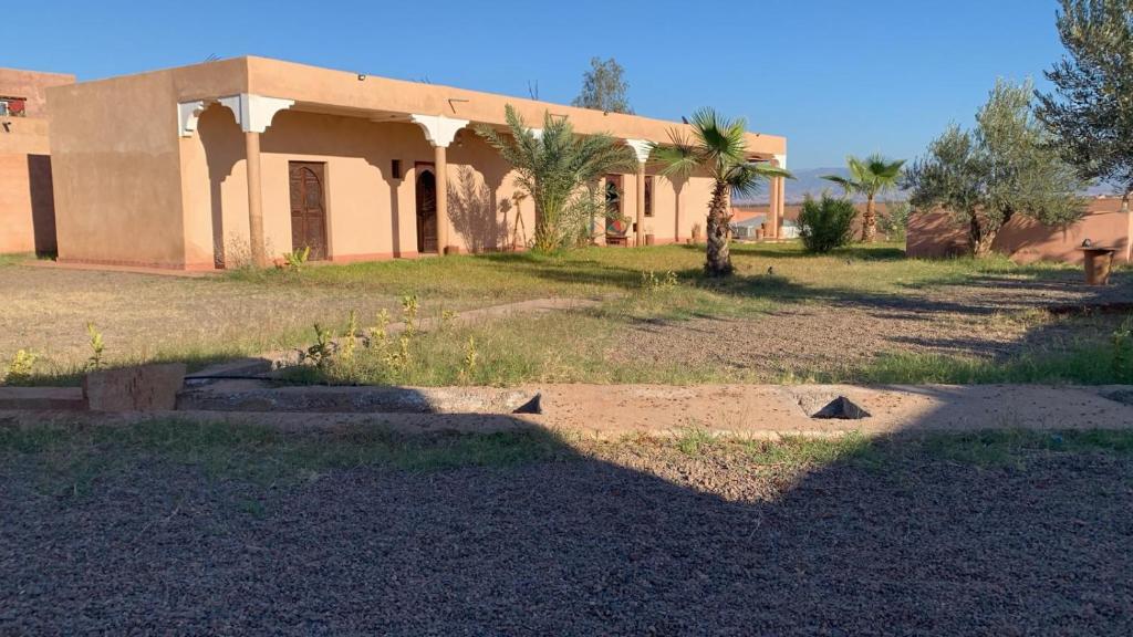 ein Gebäude mitten auf einem Feld neben einem Haus in der Unterkunft Dar Talat in Tahannaout
