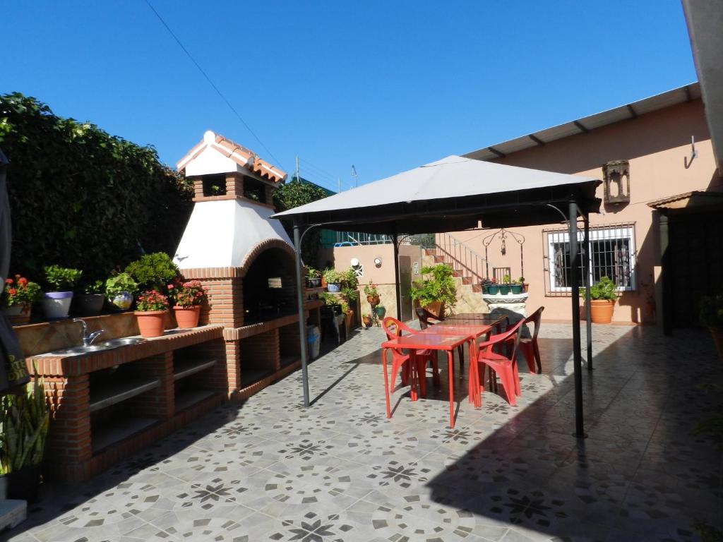 eine Terrasse mit einem Tisch und einem Pavillon in der Unterkunft Hacienda Doña Lola in Málaga