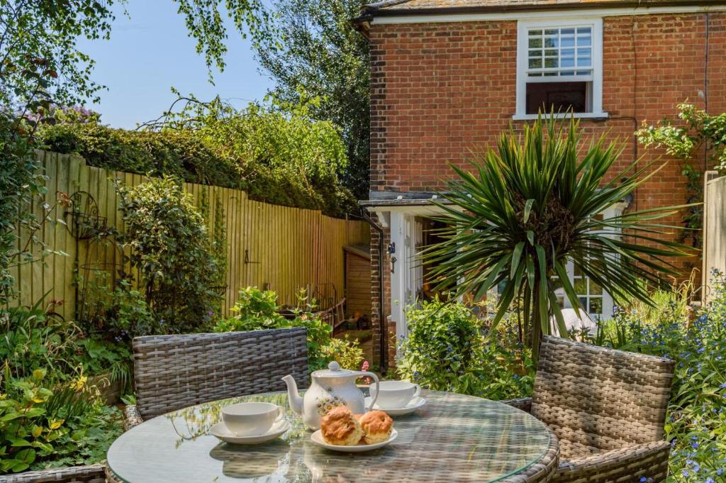 ein Tisch mit einer Schüssel mit Essen darauf in einem Garten in der Unterkunft Tail End Cottage in Rye