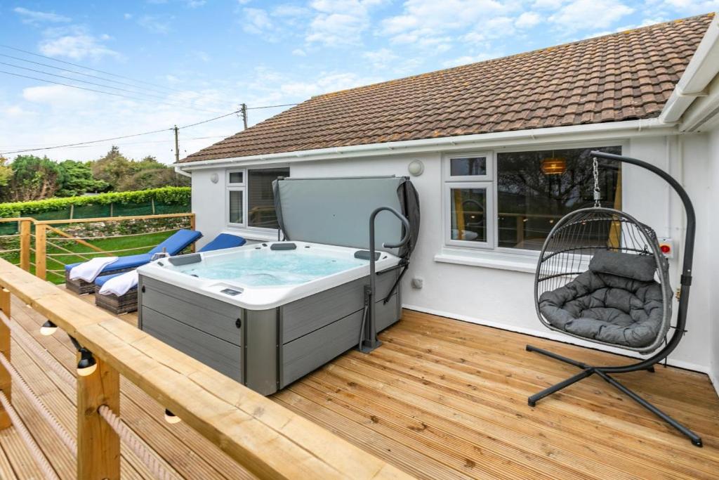 a hot tub on the deck of a house at Two-Ways in Germoe