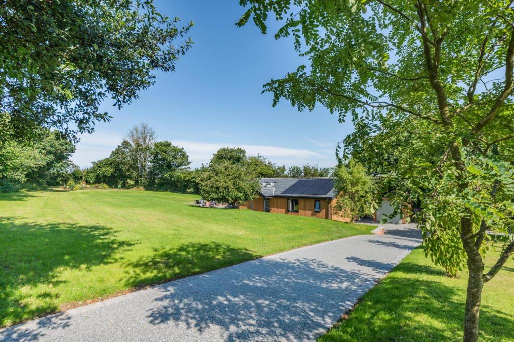 eine Auffahrt, die zu einem Haus mit großem Garten führt in der Unterkunft Little Mead in Littleham