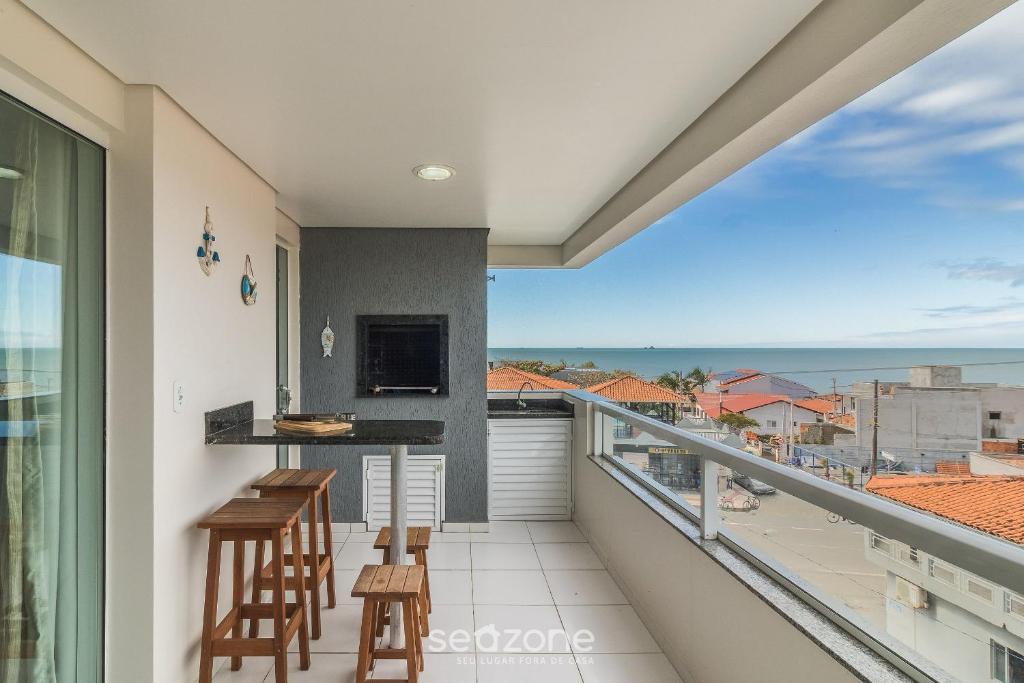 a balcony with a view of the ocean at Apto Vista Mar Lateral a 120m da Praia EEI0303 in Itajubá
