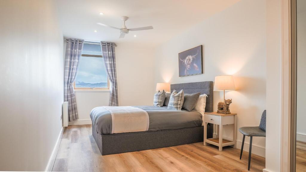 ein Schlafzimmer mit einem Bett und einem Fenster in der Unterkunft Vū by the Bridge, Inverness City Centre in Inverness