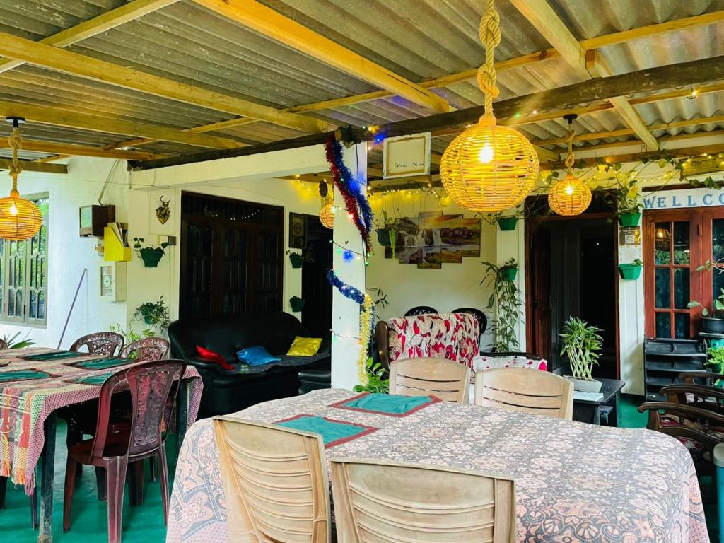 a dining room with tables and chairs and lights at sigiriya secret heaven cabana in Sigiriya
