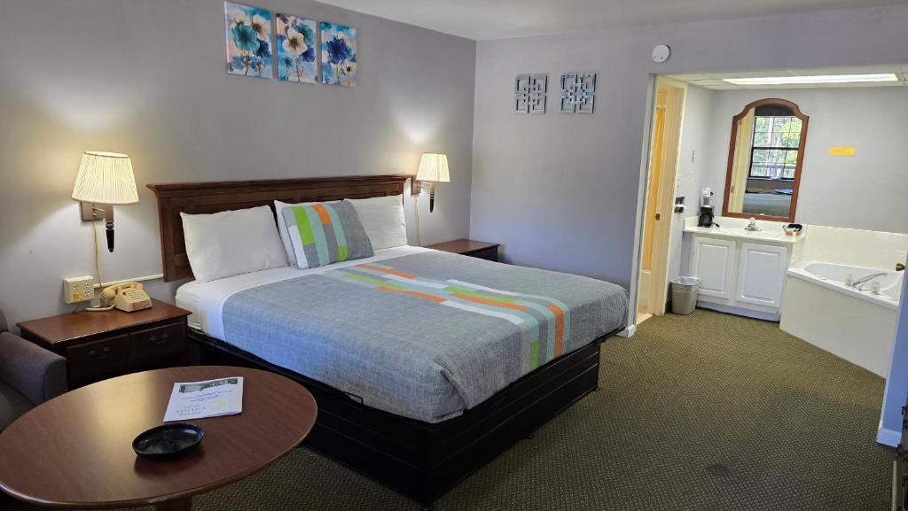 a bedroom with a bed and a bathroom with a tub at Swiss Village Inn in Eureka Springs
