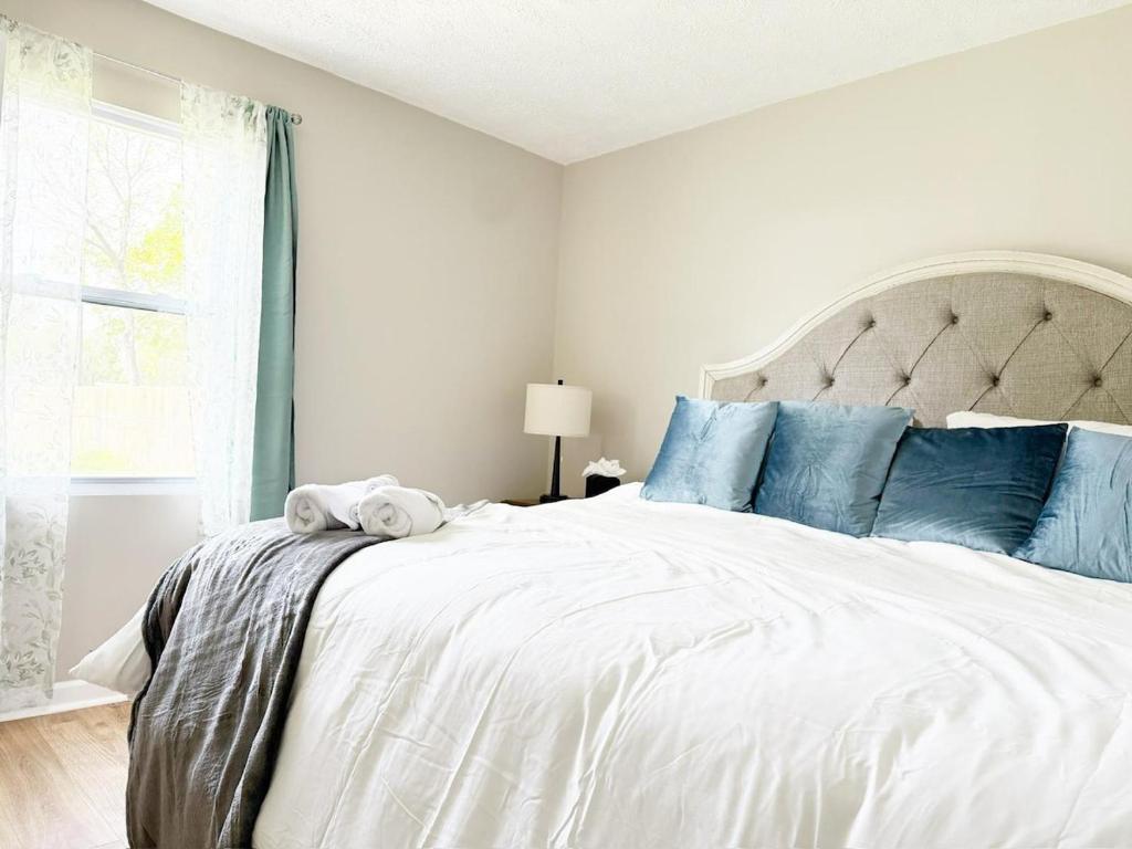 Un dormitorio con una gran cama blanca con almohadas azules. en 5th Street Retreat - KING 1BD-1BA Apt in Henderson, en Henderson
