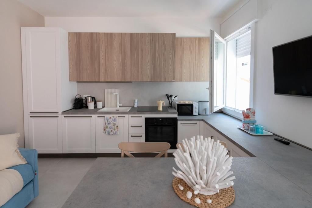 a kitchen with white cabinets and a blue couch at Ca' Cesarino in Chioggia