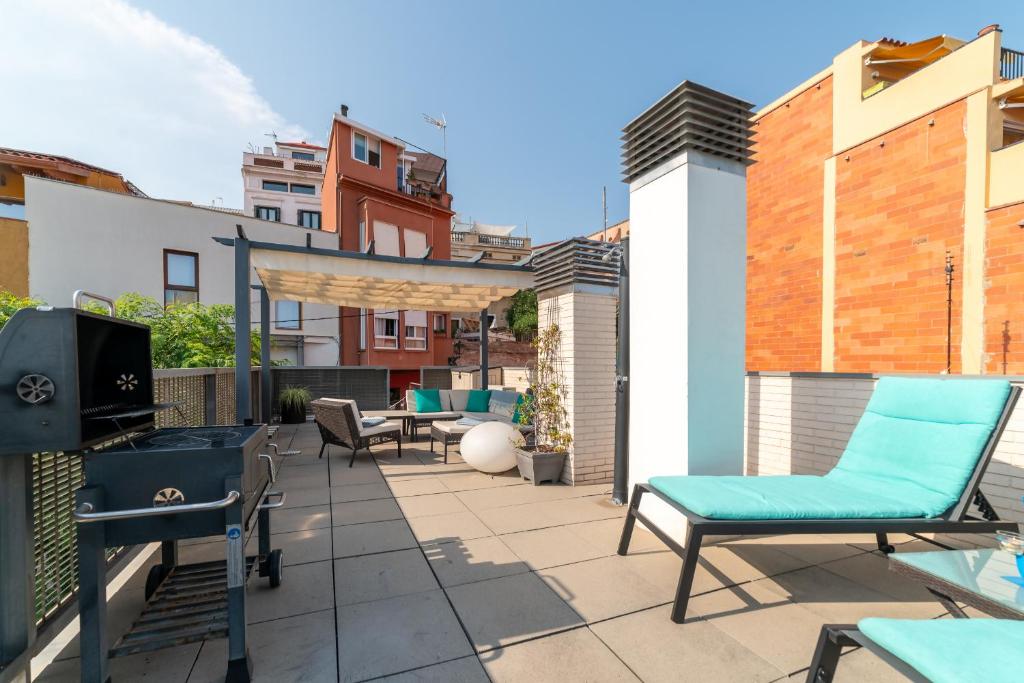 a patio with chairs and a television on a roof at Terrassa de Mar Apartment in Masnou