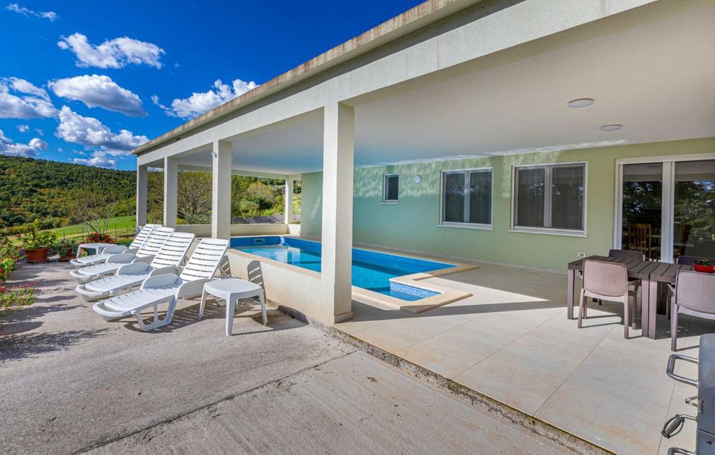 een huis met stoelen en een zwembad bij Villa Roko in Barban