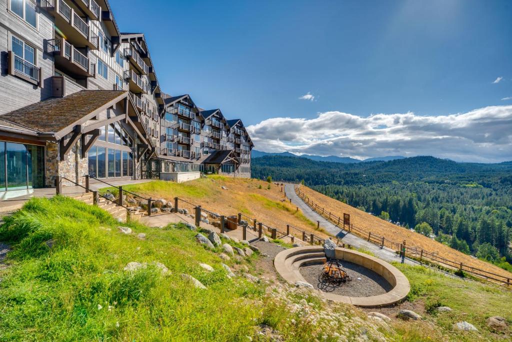 ein Gebäude auf einem Hügel mit Blick auf die Berge in der Unterkunft PNW Paradise! Lodge Condo in Suncadia Resort in Cle Elum