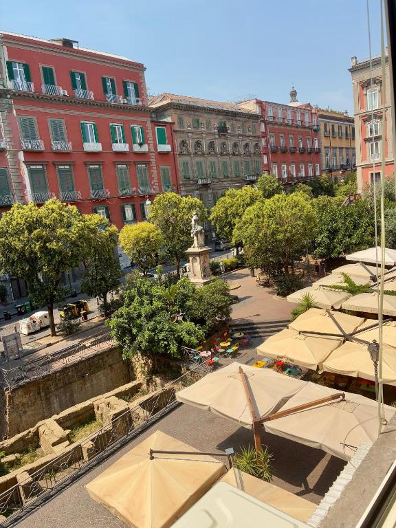 a group of tables with umbrellas in a city at TiTò Apartment in Naples