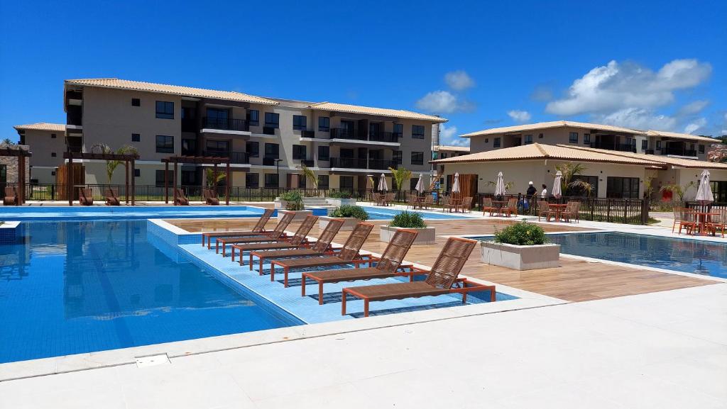 伊列乌斯Refúgio Pé na Areia - Ilhéus Vog Marine Praia的建筑物旁边有躺椅的游泳池