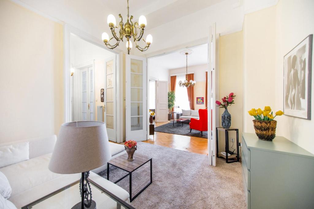 een woonkamer met een kroonluchter en een bank bij Elegant & Stylish Apartment city center in Boedapest
