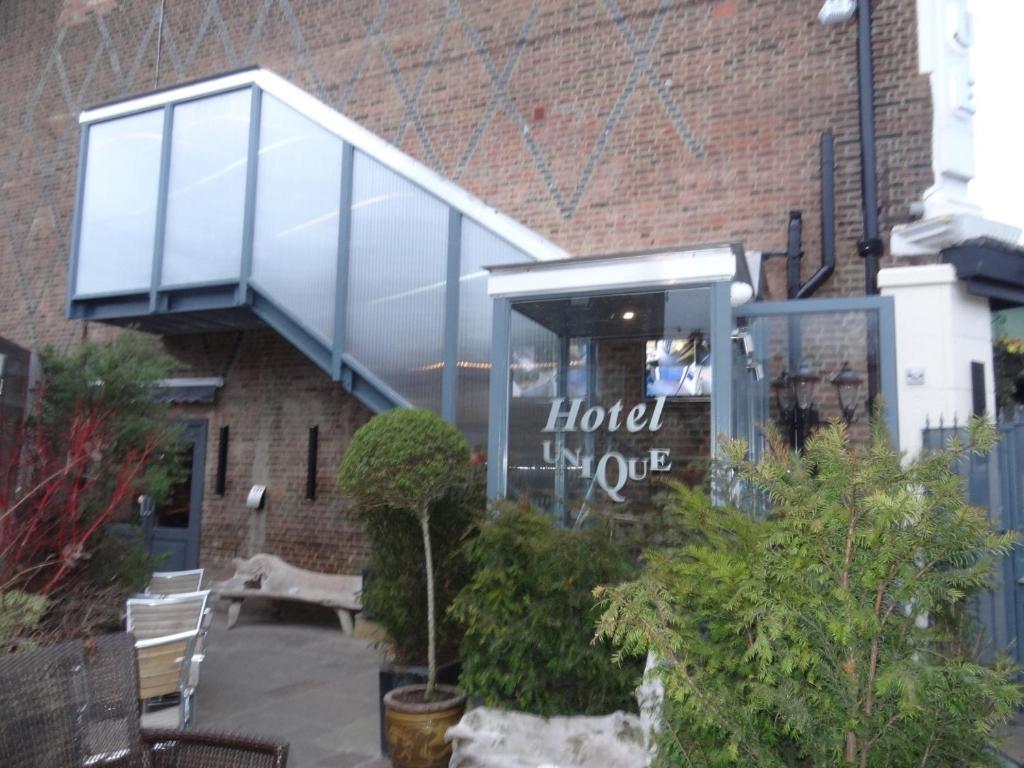 a building with a glass facade with a hotel inside at Hotel Unique in London