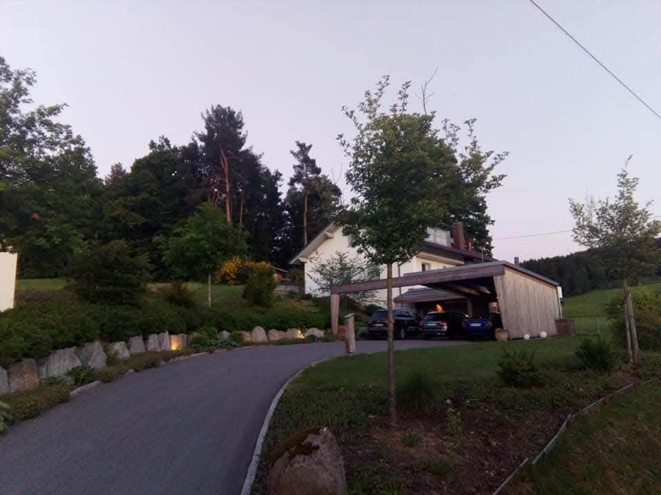 a house on a road next to a driveway at Ferienwohnung am Bühl in Cham