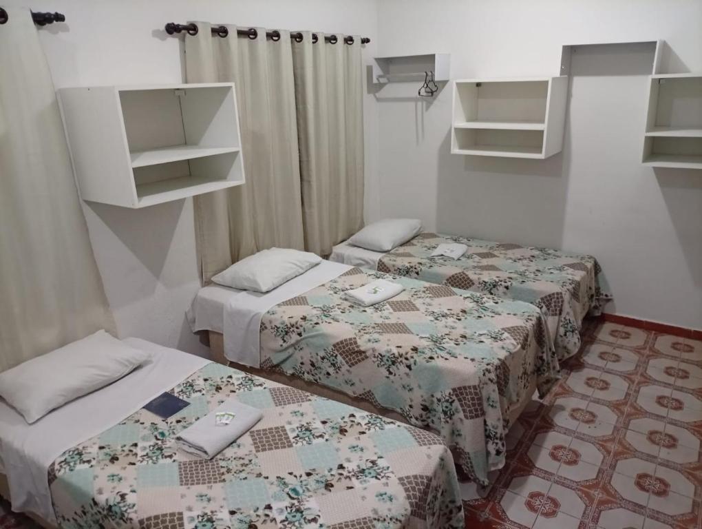 2 Betten in einem kleinen Zimmer mit 2 Betten in der Unterkunft Hotel Pousada Central Campo Grande in Campo Grande