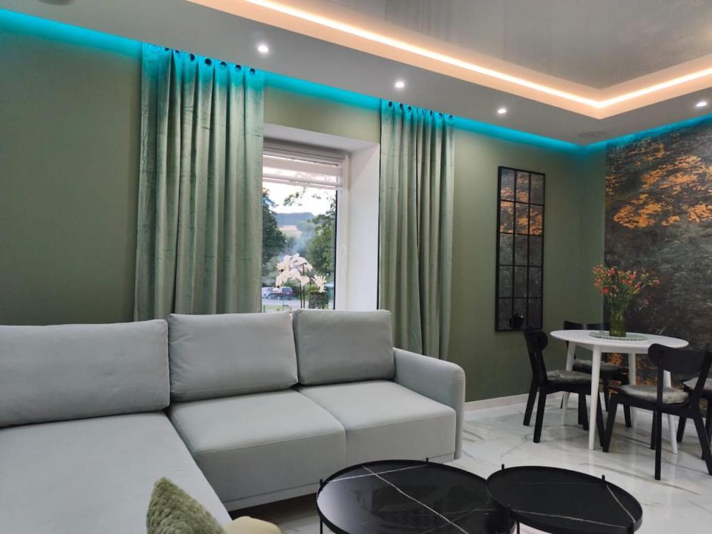 una sala de estar con un sofá y una mesa en Blu Apartments, en Jugów