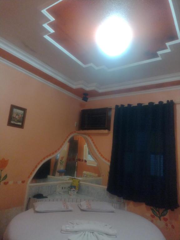 una stanza con un soffitto con una finestra e un letto di Pousada Devaneios ad Ananindeua