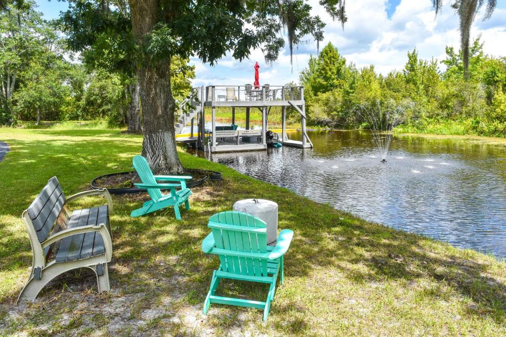 a group of chairs sitting next to a lake at Withlacoochee River Retreat with Dock Paddle and Fish in Dunnellon