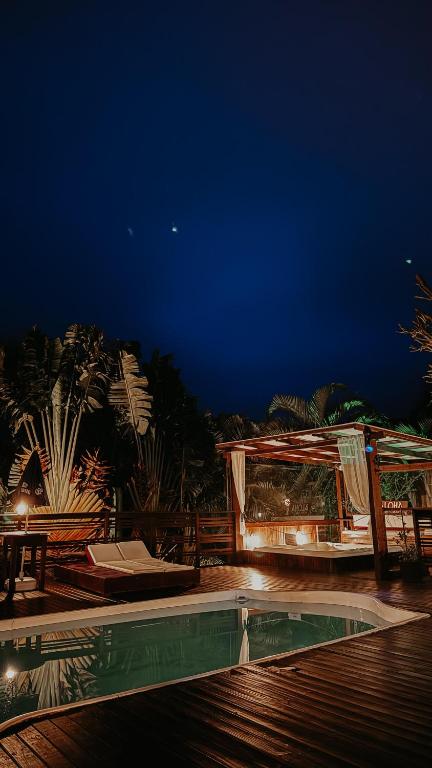 a night view of a swimming pool at a resort at Pousada Aloha Beach House in Praia do Rosa