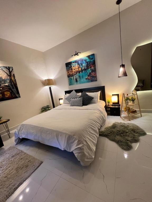 a bedroom with a large bed with white sheets at The Vaulted Retreat! F7 in Islamabad