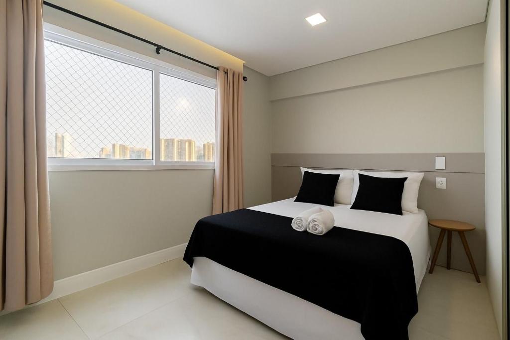 a bedroom with a black and white bed with a window at Apê no Belenzinho – Metrô Bresser / Pq. Belém in Sao Paulo
