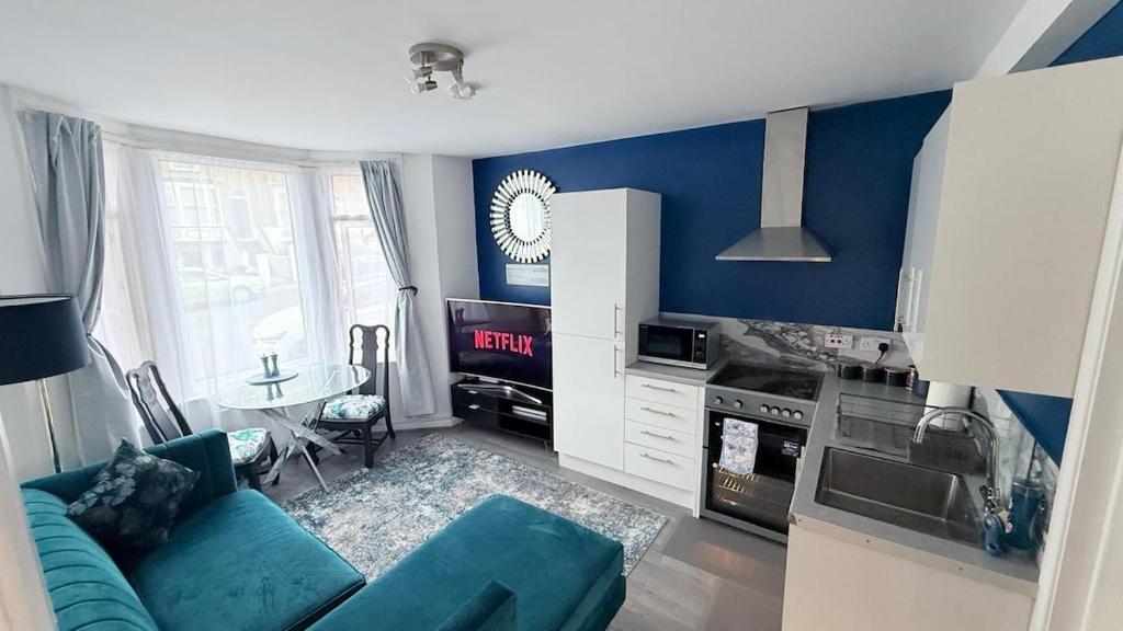 a blue living room with a couch and a table at Reverie Escape by Halisi in Ramsgate