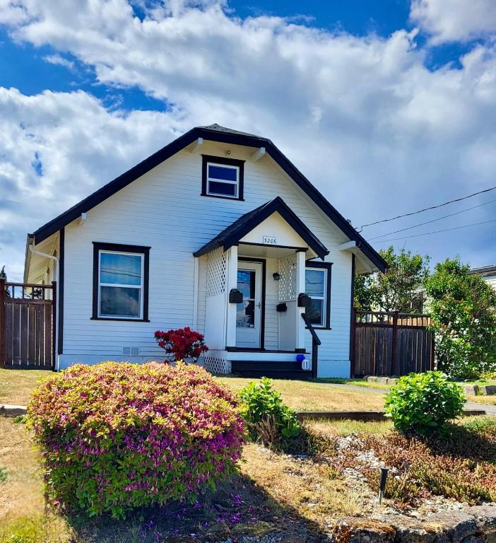 a white house with a black roof at Cottage on Durango in Tacoma