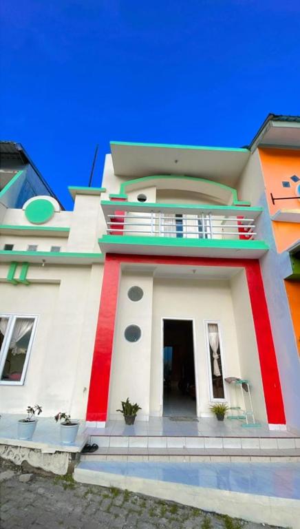 a house with a red and white at Villa Highland 9O Berastagi View in Berastagi
