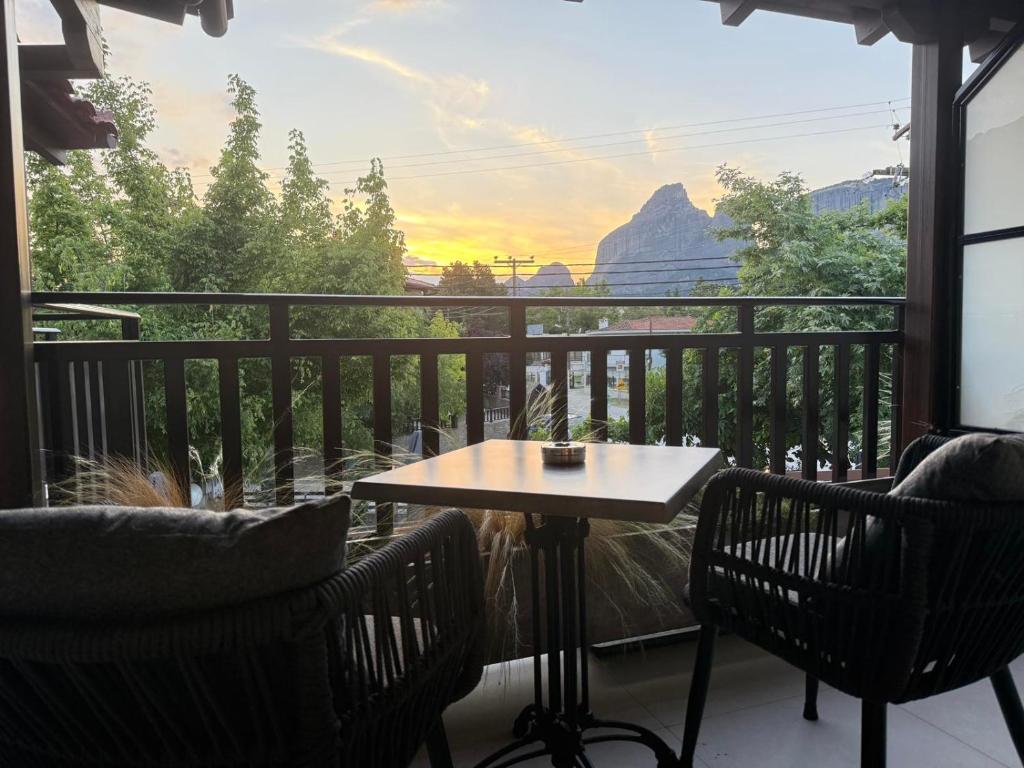 a table and chairs on a balcony with a view at Polyzos Luxury Suites Meteora #6 - Adults Friendly in Kalabaka