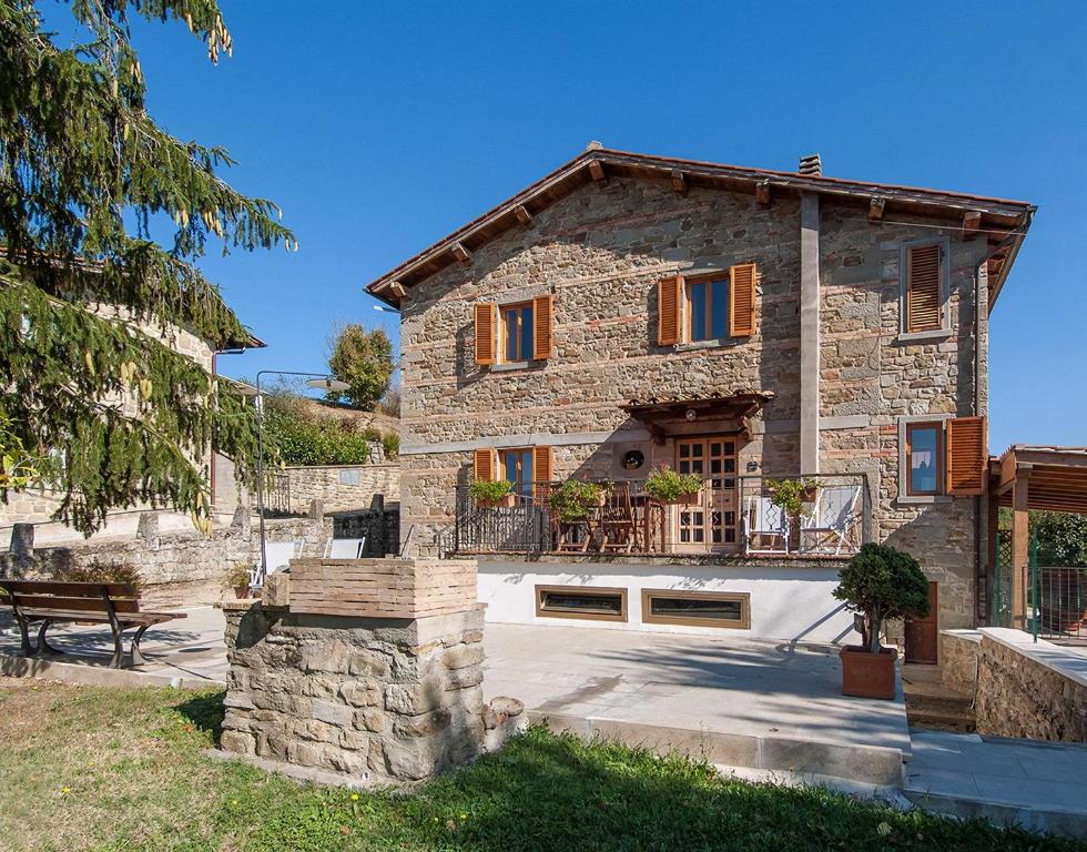 ein Steinhaus mit einer Bank davor in der Unterkunft Rustikales Natursteinhaus in der Toskana mit großem gemeinschaftlich genutzten Pool - b60232 in Pratovecchio