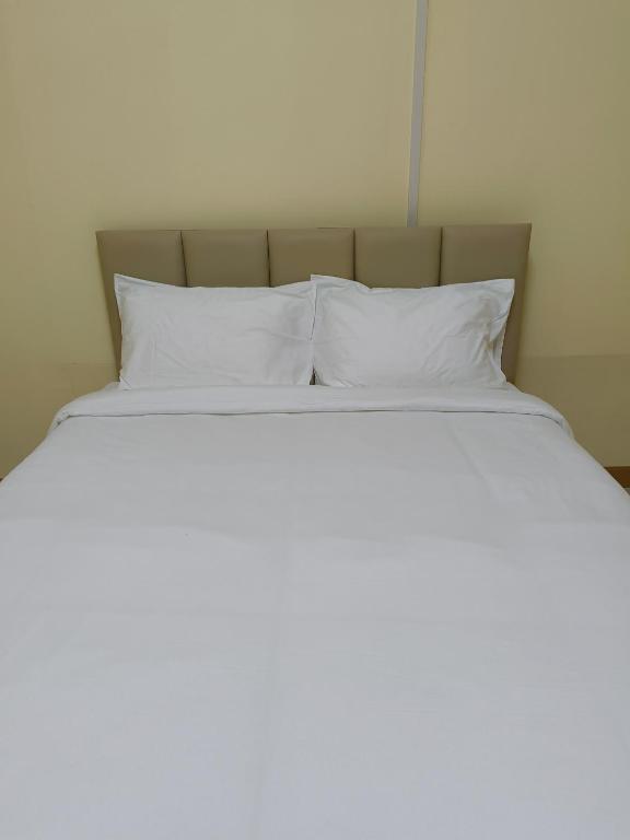 a bed with white pillows on top of it at UOKResort in Ban Bang Khen (1)