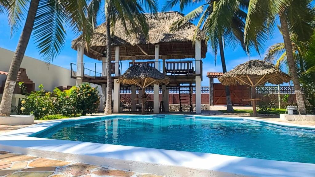 Una villa con piscina y un edificio. en Rancho Cali, Playa Las Hojas, El Salvador, en San Pedro Masahuat