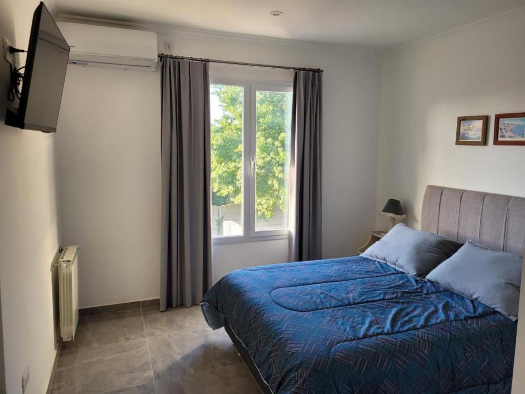 a bedroom with a bed and a window at Rincon de Mayo in Tandil