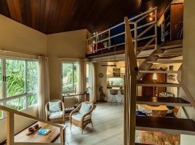 a room with a spiral staircase and a living room at Cobertura com piscina e vista da Lagoa da Conceição in Florianópolis