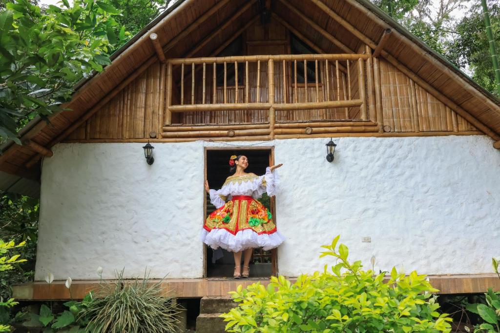 Eine Frau steht in der Tür eines Hauses in der Unterkunft Alojamiento rural Ecoparque La Motilona Paicol, Huila - Cabaña la Motilona in Paicol