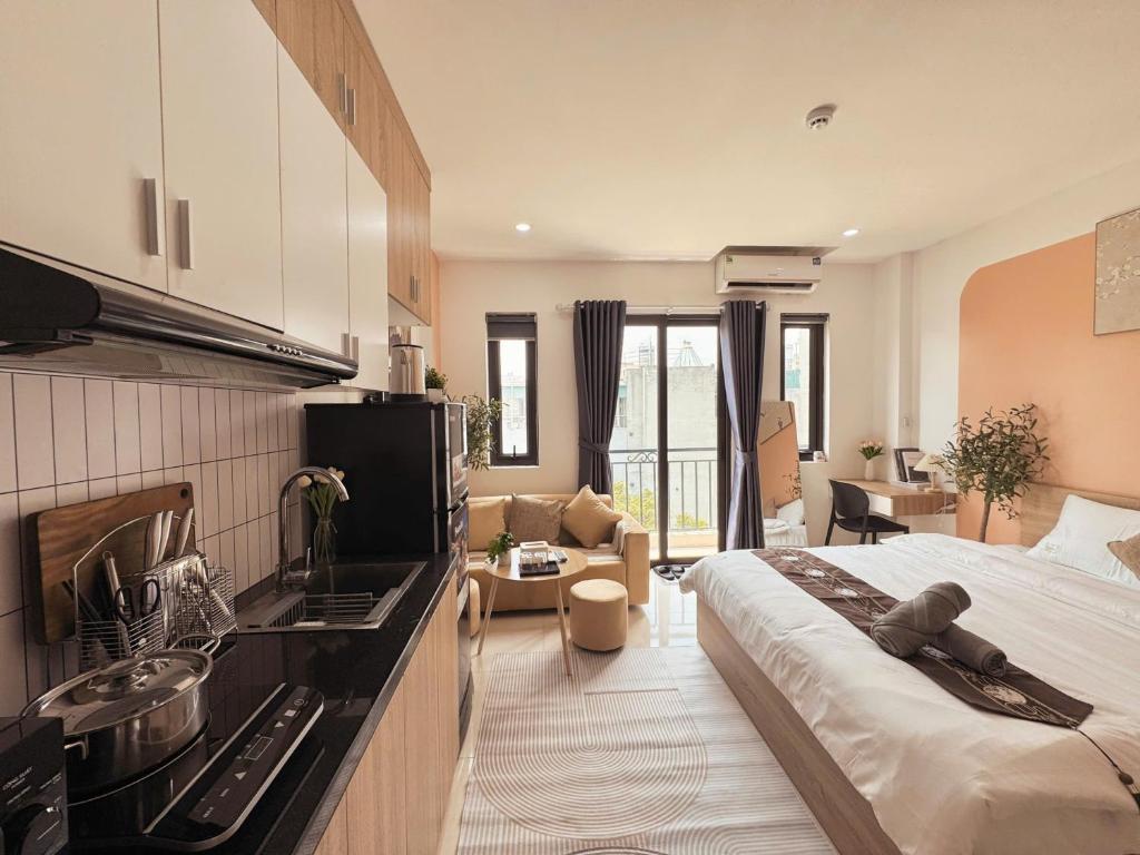 a kitchen and living room with a large bed in a room at The Little Home - Hoàng Hoa Thám - Cosy apartment - Center Hanoi in Hanoi