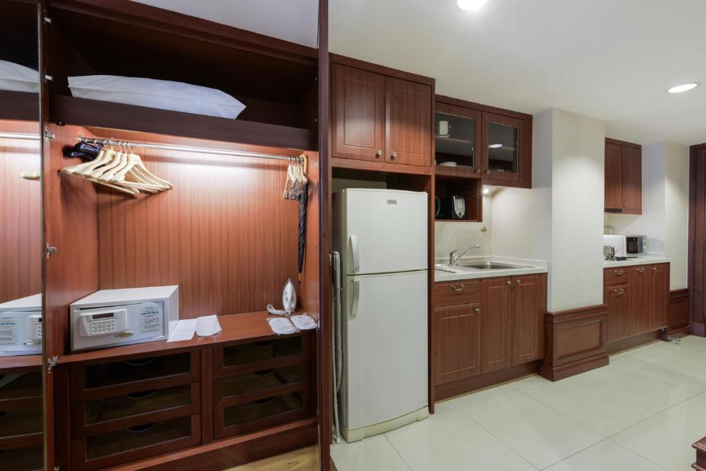 A built-in apartment kitchenette beside an open wardrobe and safe.