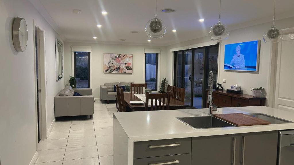 KelsoにあるLap of Luxury- Bathurst Houseのソファとテーブルのあるキッチンとリビングルーム