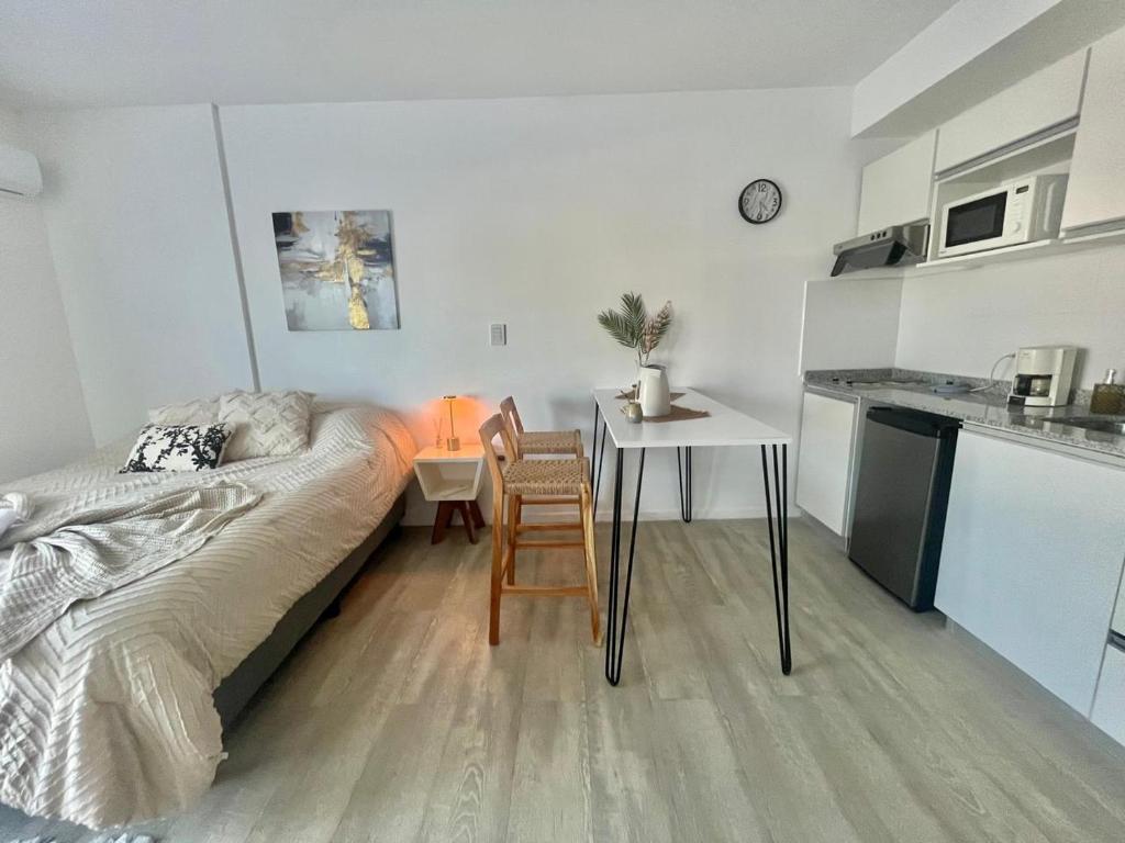 una camera con letto e tavolo e una cucina di L&M Suite Monoambiente a Belén de Escobar