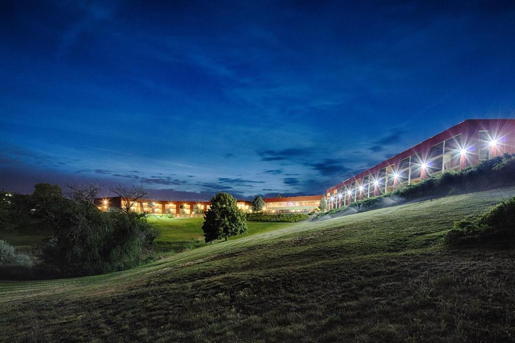 a building with lights on the side of a field at Red Lion Hotel Pendleton in Pendleton