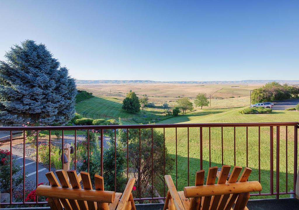 two chairs sitting on a balcony with a view of a field at Red Lion Hotel Pendleton in Pendleton