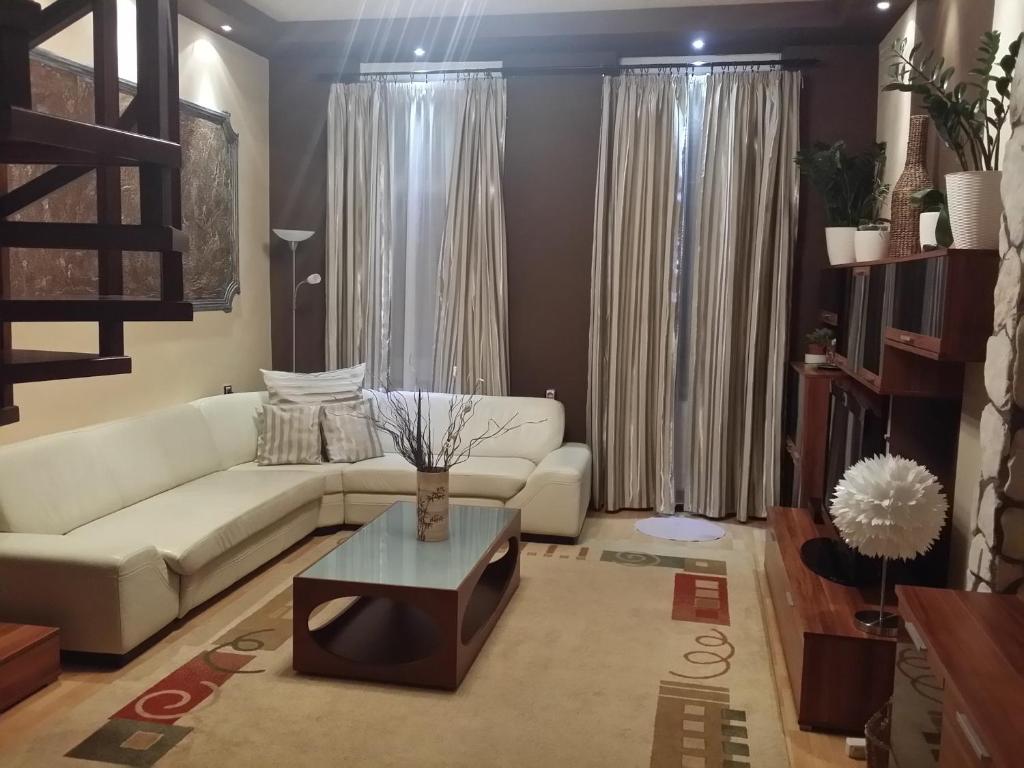 カポシュヴァールにあるKorona Apartmanのリビングルーム(白いソファ、テーブル付)
